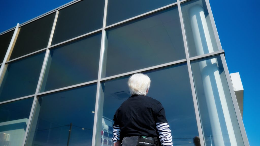Une collaboratrice du Groupe Vert regarde la taille des vitres qu'elle s'apprête à nettoyer dans le film promotionnel réalisé par 908 Films.