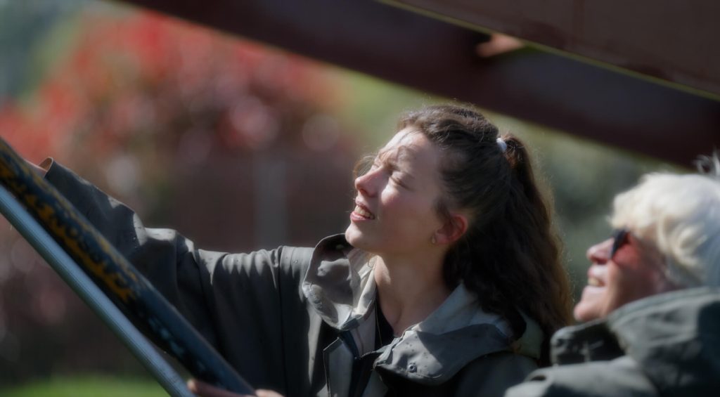 Une collaboratrice nettoie le bardage d'un client du Groupe Vert Lanvallay avec le visage ensoleillé dans le film promotionnel réalisé par 908 Films.